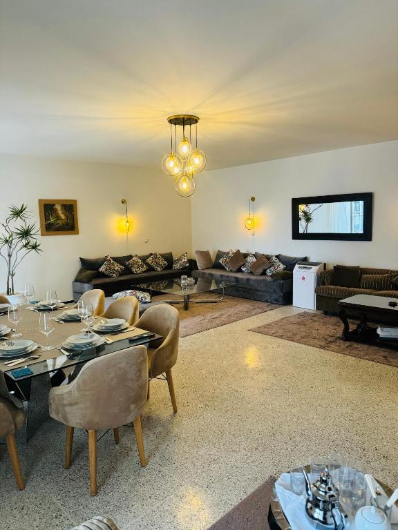 a large living room with a table and chairs at Appartement spacieux - BD Anfa in Casablanca