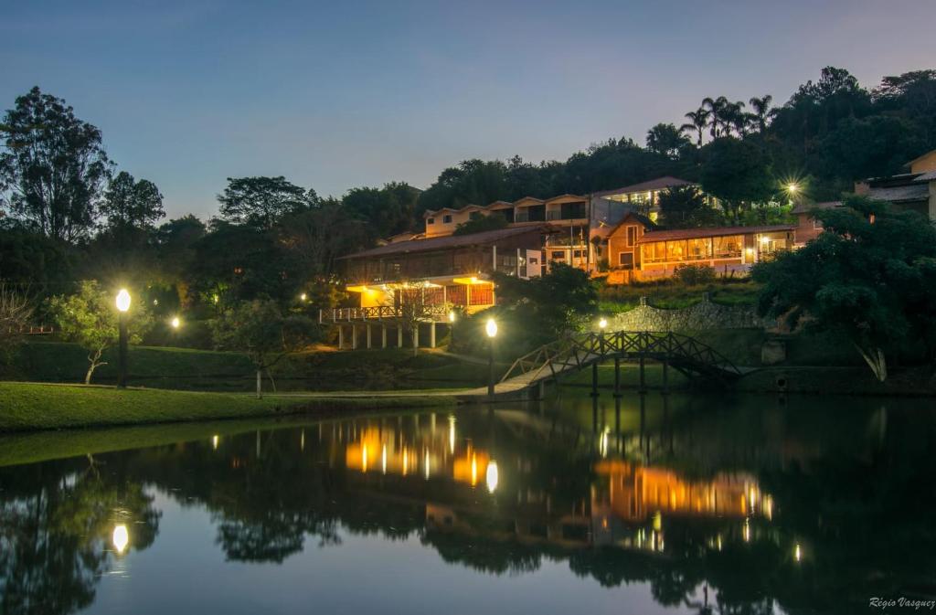 ein Haus mit einer Brücke über einen Fluss in der Nacht in der Unterkunft Hospedagem Vila Rica - 500m do centro de Cunha SP in Cunha
