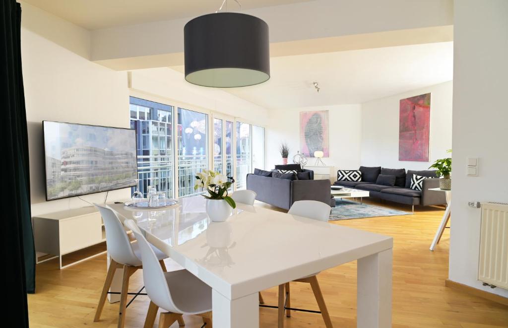 un salon avec une table et des chaises blanches dans l'établissement Victoria City and Kö Apartments, à Düsseldorf