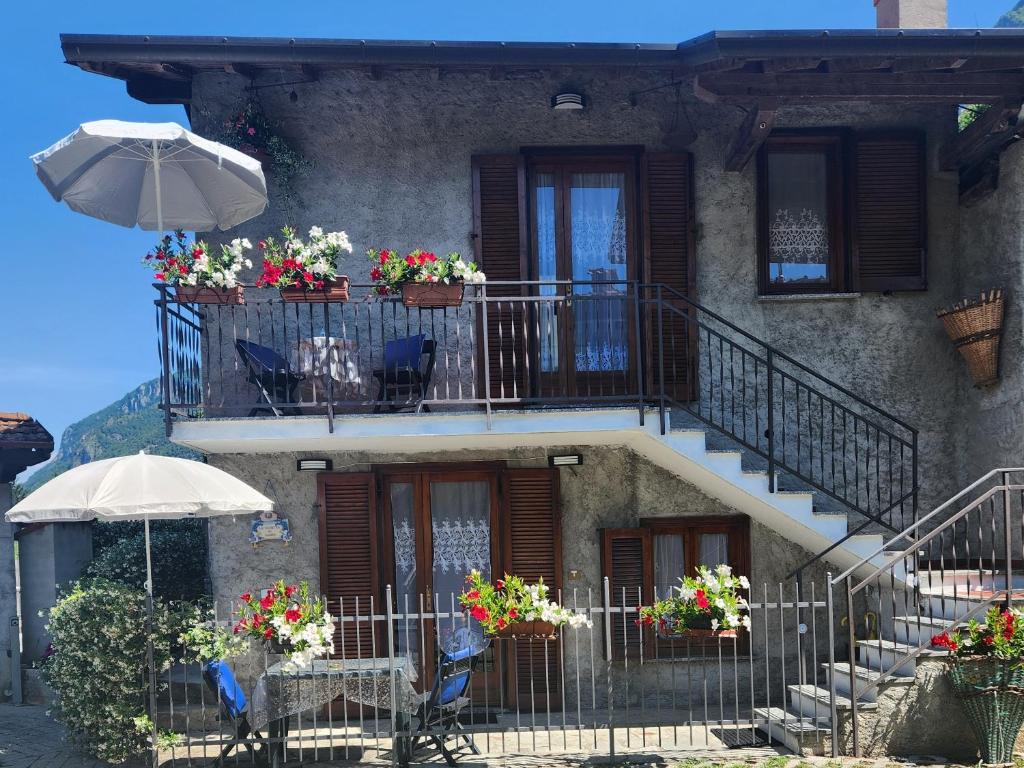 a building with stairs and tables and an umbrella at La Casetta di Laura intera casa indipendente ideale per gruppi o famiglie vista lago 5 chilometri da Varenna in Lierna