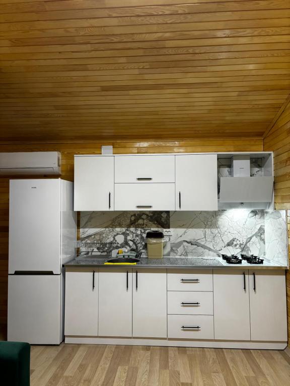 a kitchen with white cabinets and a wooden ceiling at Adrasan yeşim apart evleri in Kumluca