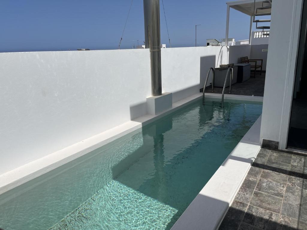 a swimming pool on the side of a white house at Pool House in La Santa