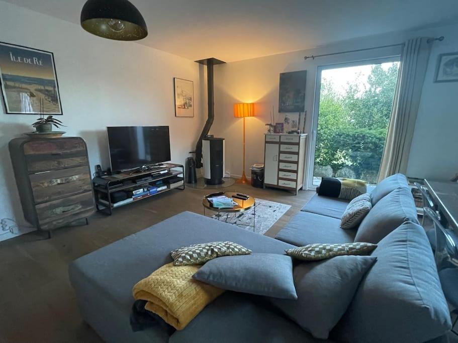 un salon avec un canapé bleu et une télévision dans l'établissement Maison rhétaise Les Grenettes, à Sainte-Marie de Ré