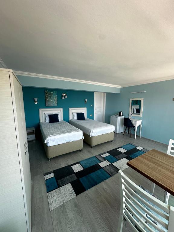 a bedroom with two beds and a blue wall at Fener Hotel Café & Kahvalti in Çeşme