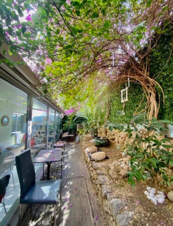 une pièce avec des bancs et un arbre avec des fleurs dans l'établissement 1 min de la plage, 3 chambres, terrasse et jardin, à Nice