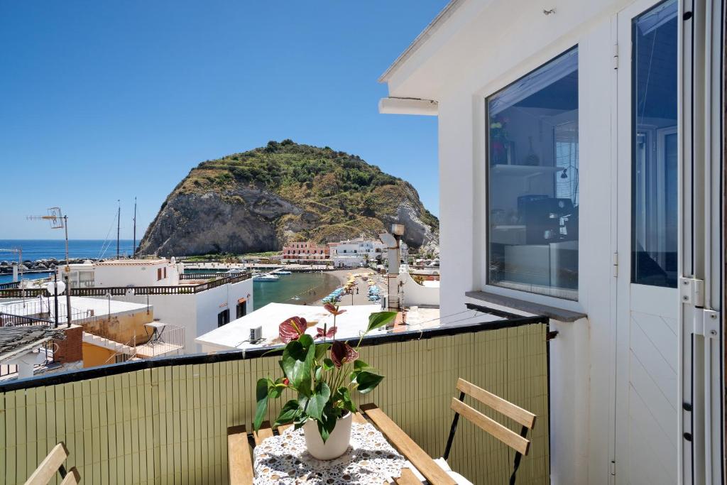 a balcony with a table and a view of a mountain at Casatullio - Sant'Angelo d'Ischia in Ischia