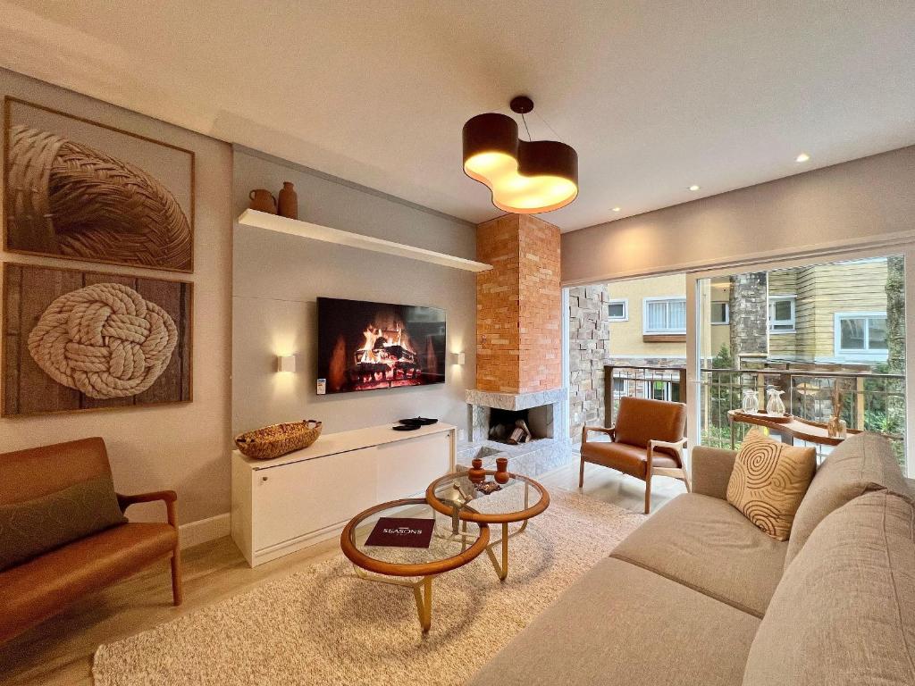Una sala de estar con un sofá y una chimenea. en Casa de Pedra 2 Suítes e Piscina by Achei Gramado, en Gramado