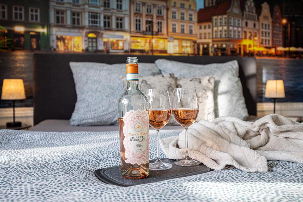 Una botella de vino sobre una mesa con dos copas. en Luxus City Apartment Sauna Balkon Küche Zentral, en Rostock