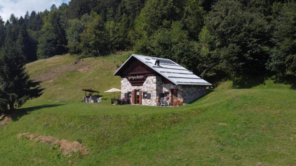 a small house on a hill in a field at Baita casapendola in Marter di Roncegno