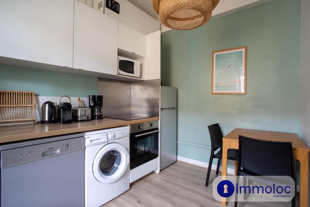 une cuisine avec une machine à laver et une table dans l'établissement Apartment with 2 bedrooms Quartier Libération, à Nice