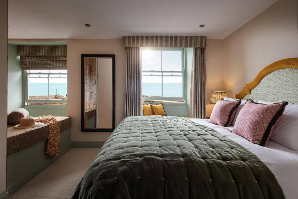 a bedroom with a large bed and a large window at Pier House in St Austell