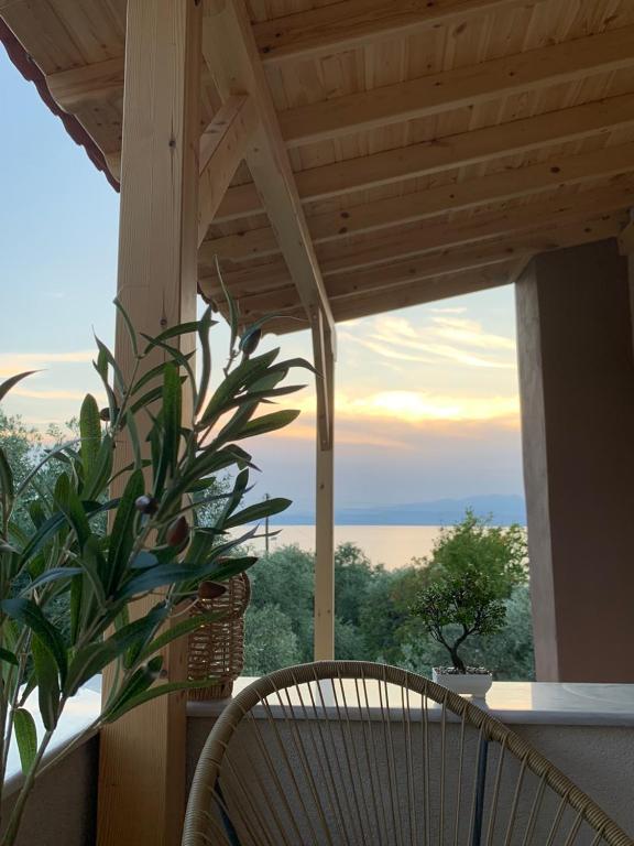 a chair on a porch with a view of the ocean at House maria elenι in Skala Kallirachis
