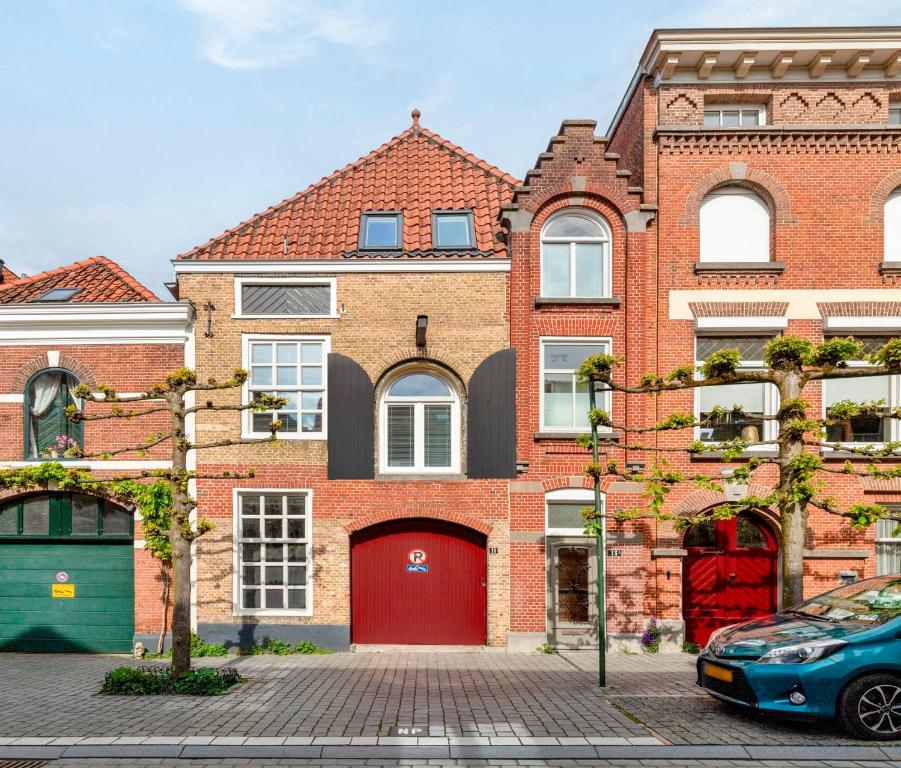 a red brick house with a red garage at De Kleine Lantaarn in Bergen op Zoom