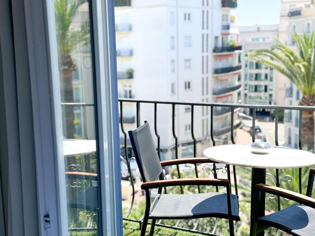 a balcony with a table and chairs and a table at Hôtel de Provence in Cannes