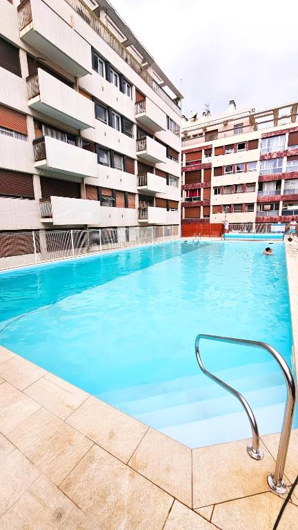 une grande piscine devant un immeuble dans l'établissement Doudoute's Cosy Home, à Perpignan