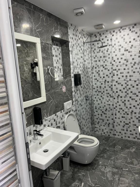 a bathroom with a toilet and a sink at Ilio Boutique Hotel in Ksamil