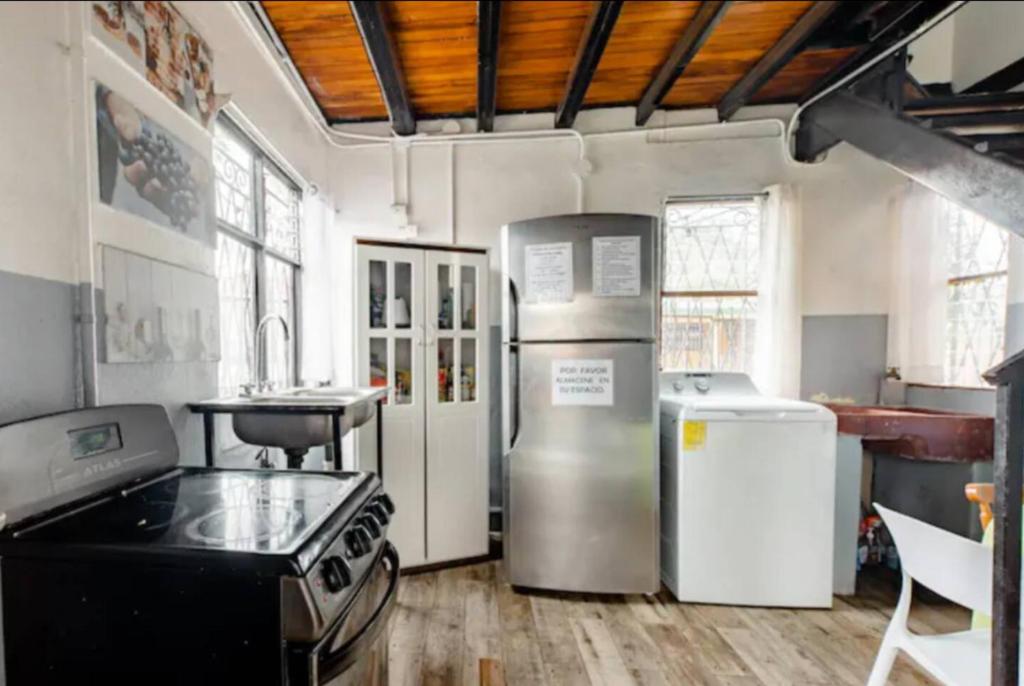 une cuisine avec une cuisinière et un réfrigérateur dans l'établissement Habitaciones Smith, à San José