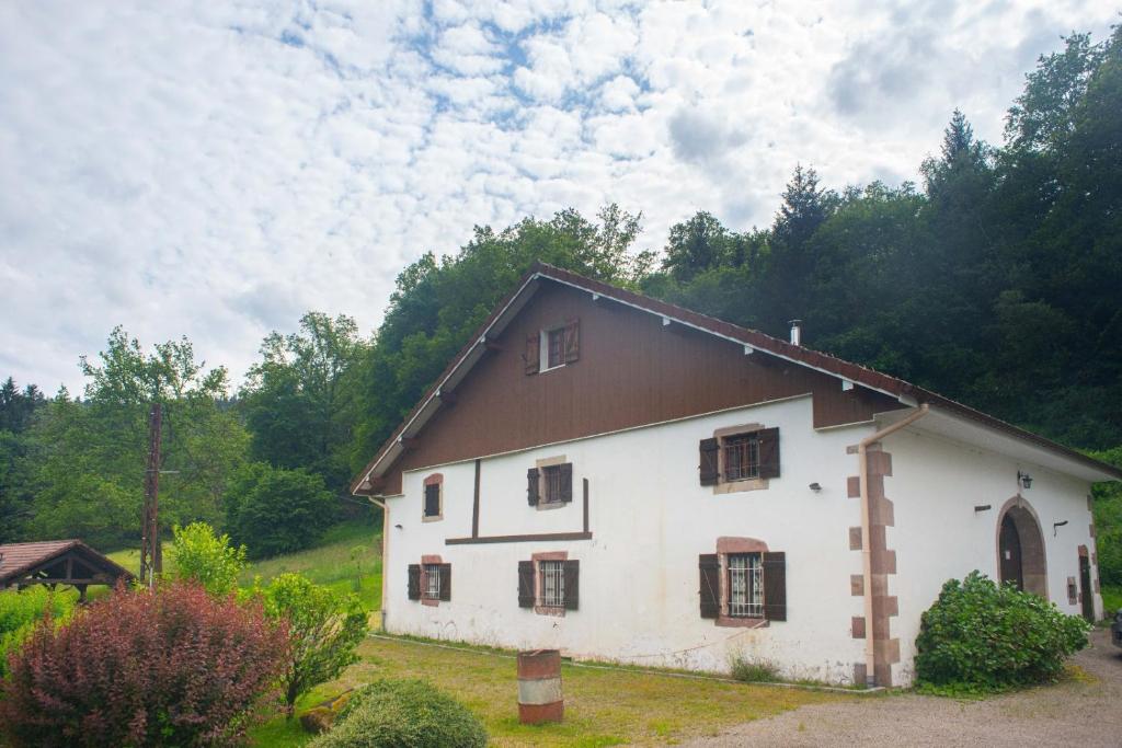 una casa blanca con techo marrón en La ferme aux belles sources, en Dommartin-lès-Remiremont