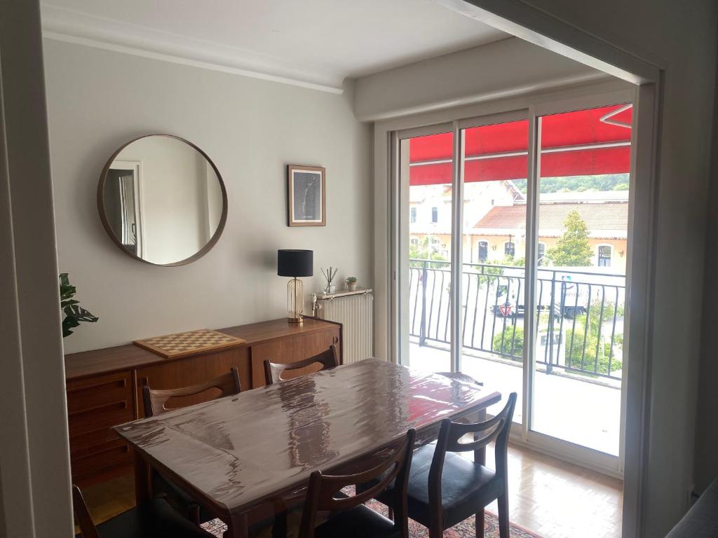 une salle à manger avec une table et un miroir dans l'établissement Arcachon, à Arcachon