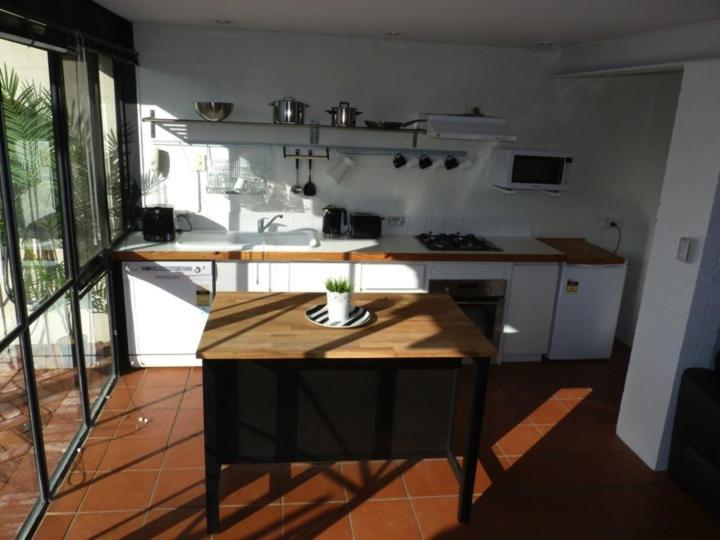a kitchen with a wooden island in a room at Penny's Place in Fremantle