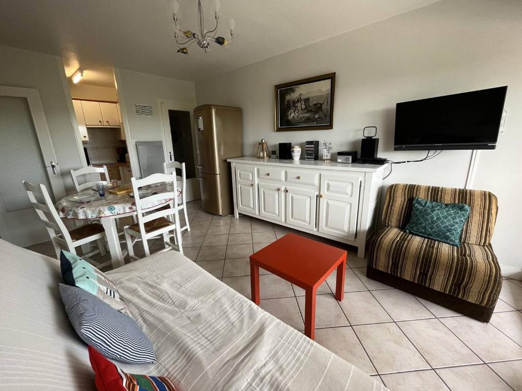 - un salon avec un lit, une télévision et une table dans l'établissement Appartement T2 entre plage et commerces, loggia, parking privé, proche pistes cyclables - FR-1-324A-60, à Saint-Hilaire-de-Riez