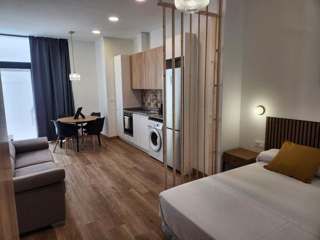 a bedroom with a bed and a table and a kitchen at Dormavalencia Crónica in Valencia