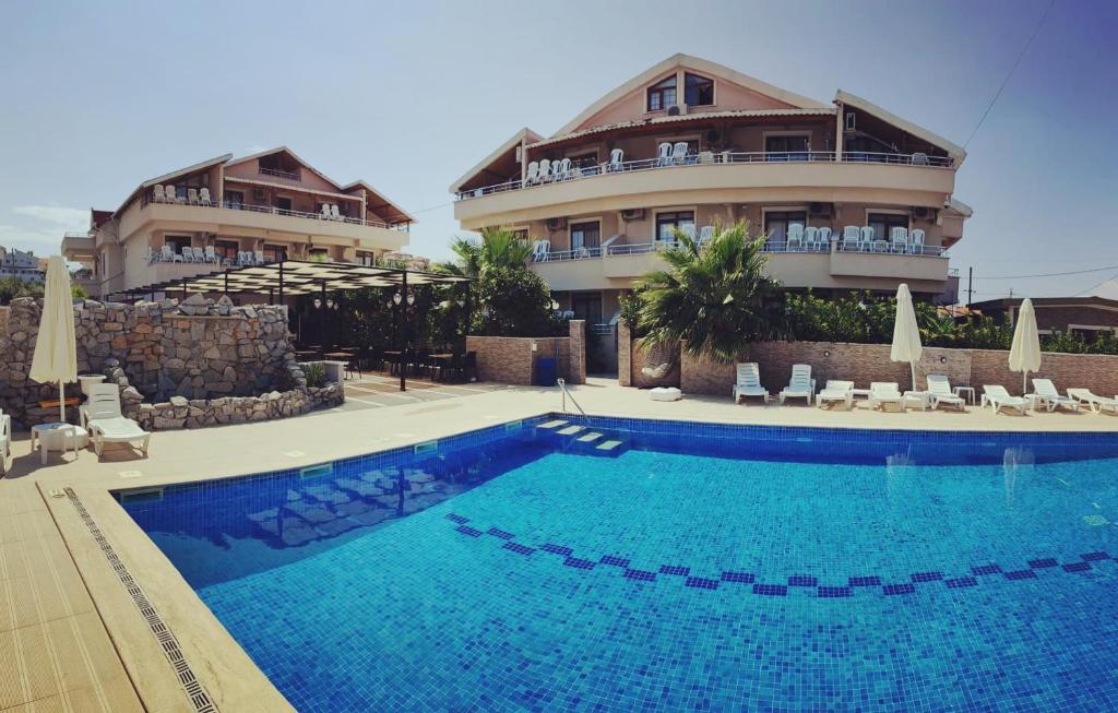 a large swimming pool in front of a building at Altinkum tatil konakları in Yiğitler