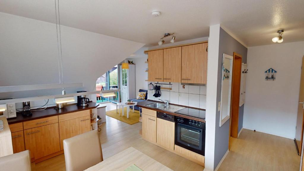 a kitchen with wooden cabinets and a counter top at Ort Lemkenhafen "Westwind" in Westfehmarn