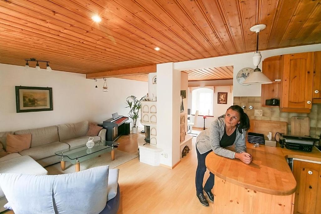 a woman standing at a wooden table in a living room at Ferienwohnung Obermühle in Alter Graben