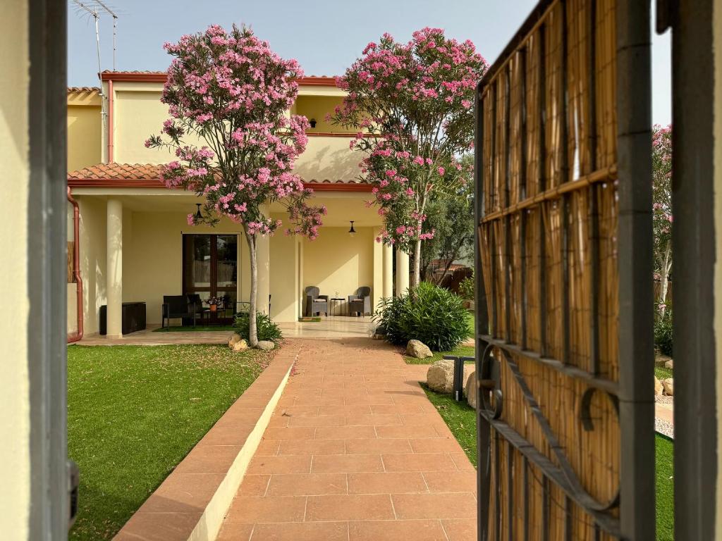 una porta aperta su una casa con fiori rosa di Villa Oliva in Quartu Sant Elena, Capitana, with big Garden and Sea view! a Capitana