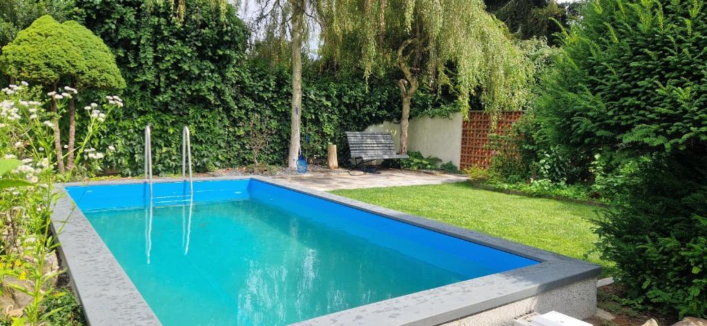 una piscina en un jardín con un banco en Relax apartmán Pod Javorem, en Kladno