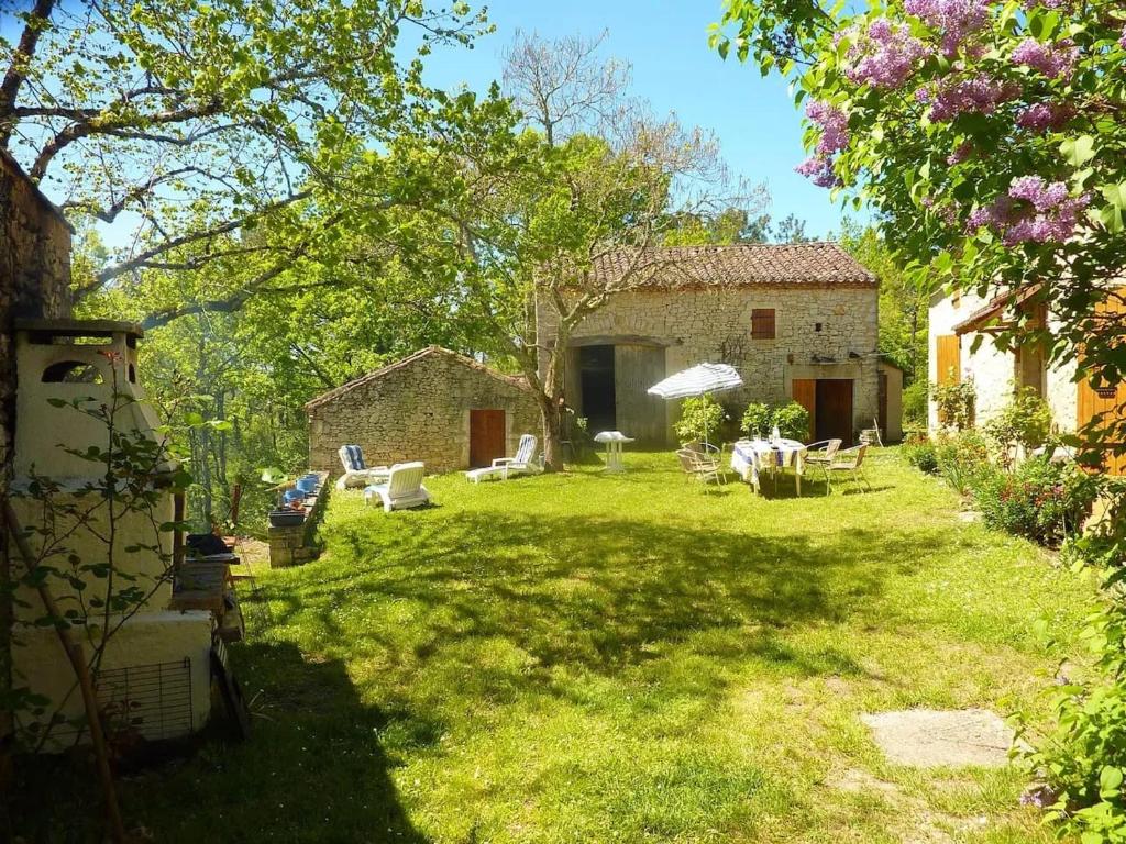 a yard with lawn chairs and a building at Maison charmante à Les Junies avec vue sur jardin in Les Junies