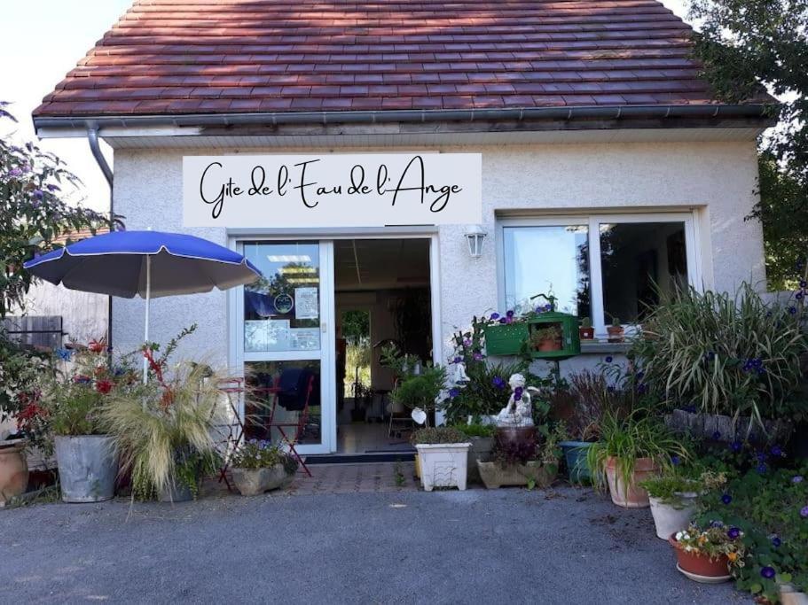 a flower shop with an umbrella in front of it at Gîte de l’eau de l’ange in Audelange