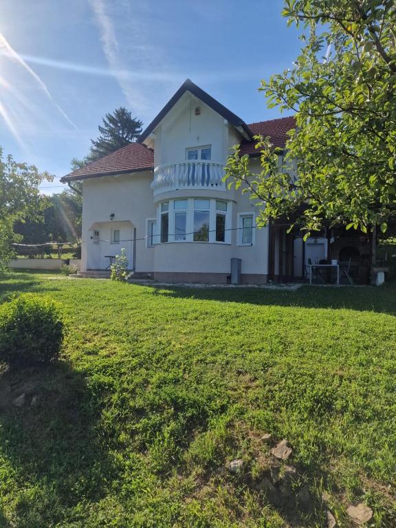 une grande maison blanche avec une grande cour dans l'établissement Vila av lugnet, à Kobiljača