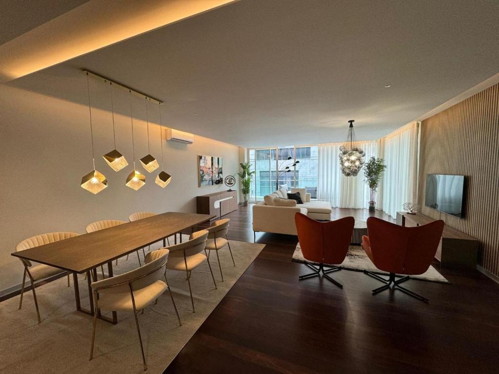 a dining room and living room with a table and chairs at Funchal Next Corner Plaza in Funchal