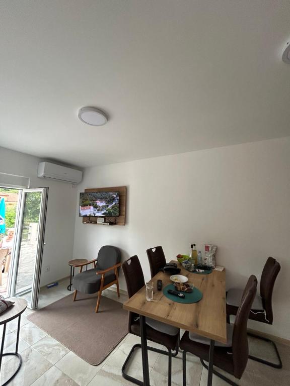a living room with a wooden table and chairs at Apartmani Marinee in Donja Jošica