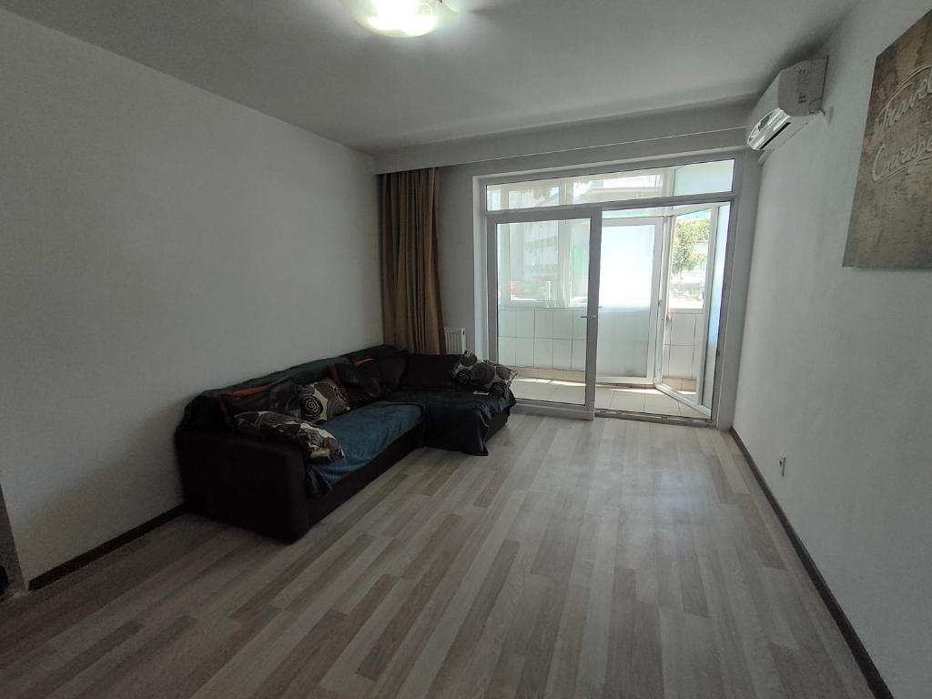 a living room with a couch and a large window at La Constanta Gara in Constanţa