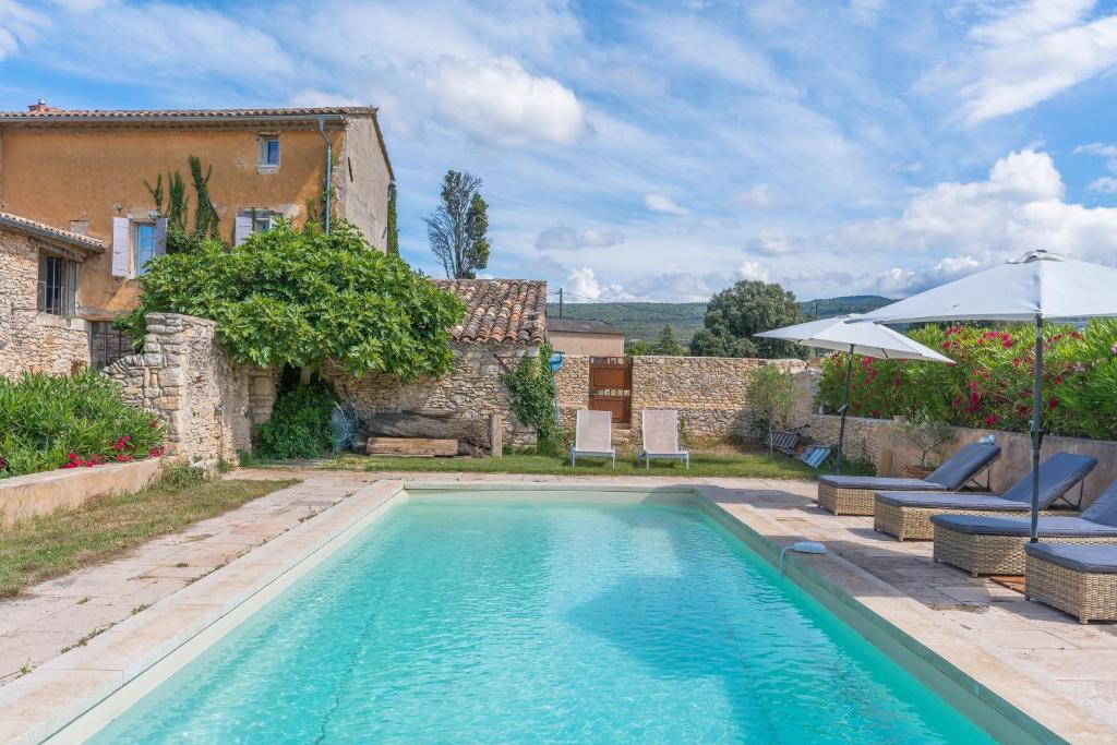 une piscine devant une maison dans l'établissement Mas Ancien Dans Les Vignes, à Saint-Saturnin-lès-Apt