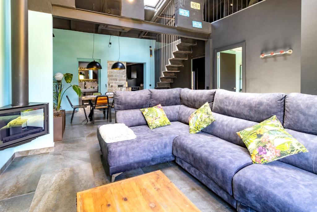 a living room with a couch and a tv at Black House- Sorprendente casa estilo industrial in Olot