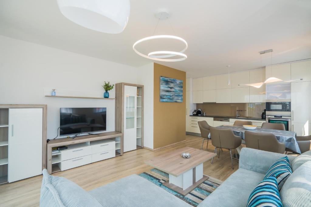 a living room with a blue couch and a kitchen at Blue Apartman Szántód in Szántód