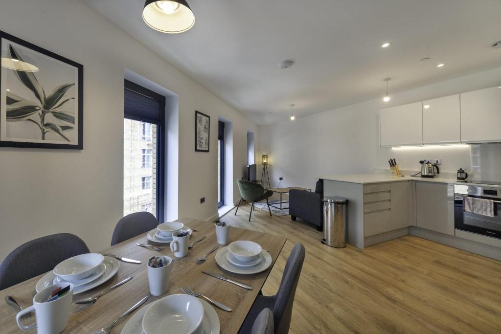 a dining room table with chairs and a kitchen at Fantastic 2 Bedroom Apartment in Central Ashford in Ashford