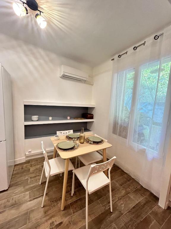 une salle à manger avec une table et des chaises et une fenêtre dans l'établissement cassis studio 50m de la grande plage, à Cassis