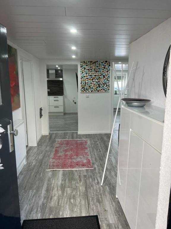 a room with a kitchen with a door and a rug at Merys Home in Günzburg