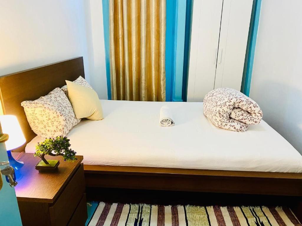 Una cama con dos almohadas encima en una habitación. en Kuti Hostel, en Lisboa