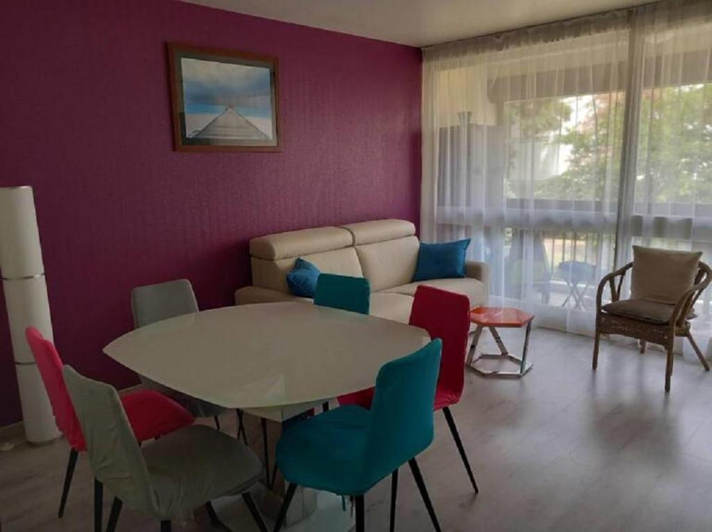 un salon avec une table, des chaises et un canapé dans l'établissement SOLEIL 4 ét, à Saint Cyprien Plage