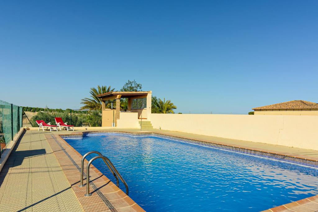 ein Pool mit blauem Wasser und zwei Stühlen in der Unterkunft Cortijo de Fidel in Vera