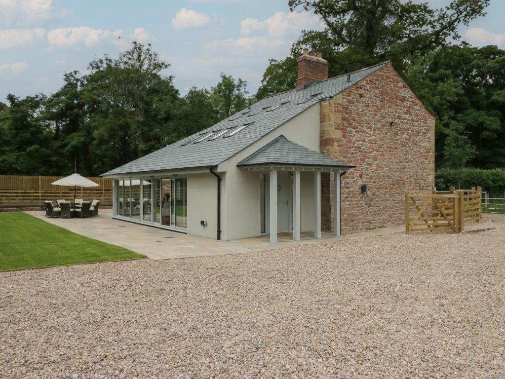 a brick building with a roof with a patio at Heather's Cottage in Carlisle
