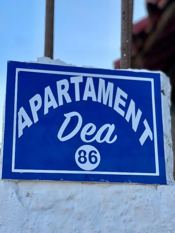 a blue sign on a wall with a sign for aarwegian sea at Guest House DEA in Vlorë