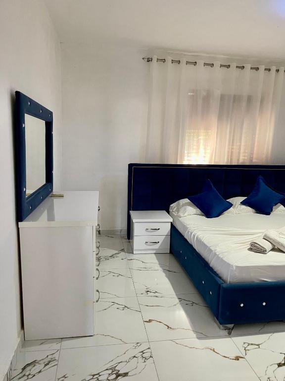 a bedroom with a bed and a dresser with a mirror at Guest House DEA in Vlorë