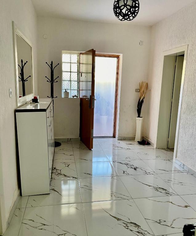 a living room with a marble floor and a door at Guest House DEA in Vlorë